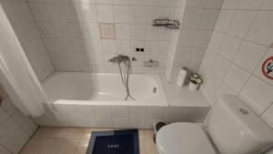 a white bathroom with a tub and a toilet at Family House Kat in Ioannina +31 photos