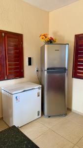 a refrigerator with a vase of flowers on top of it at Casa da Duna Moitas-Icaraizinho de Amontada Ceará in Praia de Moitas