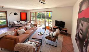 a living room with a couch and a tv at AlpenLodge Chiemsee in Nußdorf