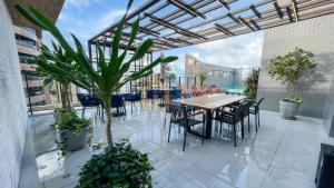 an outdoor patio with tables and chairs and plants at Unigreen Manaíra Genius Flats in João Pessoa
