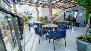 a patio with tables and chairs and an umbrella at Unigreen Manaíra Genius Flats in João Pessoa