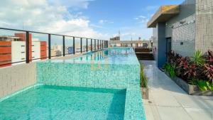 a swimming pool on the roof of a building at Unigreen Manaíra Genius Flats in João Pessoa