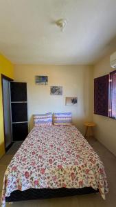 a bedroom with a large bed with a floral bedspread at Casa da Duna Moitas-Icaraizinho de Amontada Ceará in Praia de Moitas +27 photos
