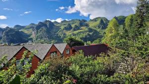 a group of houses with mountains in the background at Plum Hillside Lodge in Dồng Văn