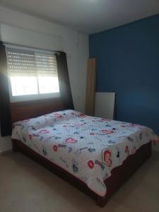 a bedroom with a bed with a comforter and a window at בית בערבה in Mitzpe Ramon