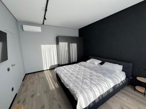 a bedroom with a bed and a black wall at Bavaro apartments 5 in Ivano-Frankivsk