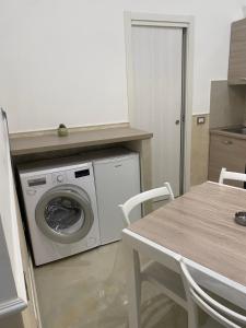 a kitchen with a washing machine and a table at Casa Planzio in Naples +33 photos