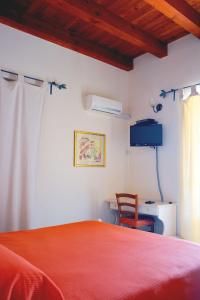 a bedroom with a red bed and a chair at Agriturismo Arona in Sperlinga