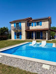 a villa with a swimming pool in front of a house at Villa Francesca with Private Pool & Designer Interior in Kaštel