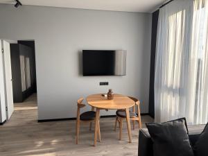 a dining room with a table and a tv on a wall at Bavaro apartments 5 in Ivano-Frankivsk