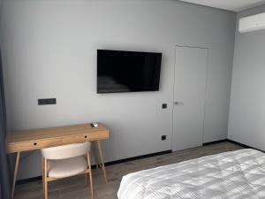 a bedroom with a desk and a tv on a wall at Bavaro apartments 5 in Ivano-Frankivsk