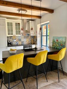 a kitchen with yellow chairs and a kitchen island at Villa Francesca with Private Pool & Designer Interior in Kaštel
