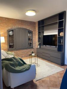 a living room with a couch and a television at Liber Barbaresco House in Barbaresco
