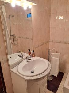 a bathroom with a sink and a shower and a tub at Casa da Miquinhas I in Ponte da Barca