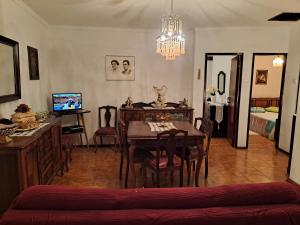 a living room with a dining room table and a chandelier at Casa da Miquinhas I in Ponte da Barca +11 photos