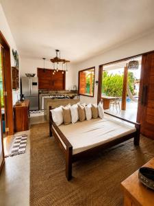 a living room with a couch and a kitchen at CASA SIMONI Trancoso in Trancoso