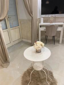 a white table with a vase of flowers on it at Casa Planzio in Naples