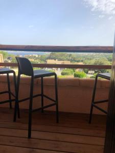 two chairs and a table on a balcony with a view at Casamea - T2, Piscine, Vue Mer, Clim, Balcon in Porticcio
