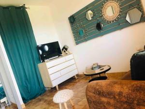 a living room with a couch and a dresser with a mirror at Casamea - T2, Piscine, Vue Mer, Clim, Balcon in Porticcio
