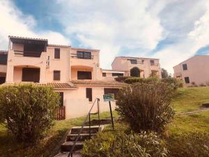 a house on a hill with bushes in front of it at Casamea - T2, Piscine, Vue Mer, Clim, Balcon in Porticcio