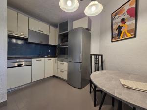 a kitchen with a table and a stainless steel refrigerator at Vila Ivana Jadranovo in Jadranovo