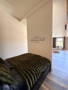 a bed in a room with a writing on the wall at B&B Goeje Morge in Ammerzoden