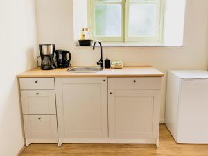 a kitchen counter with a sink and a window at Modern Studio 1 in Historic Abbey in Cadier en Keer