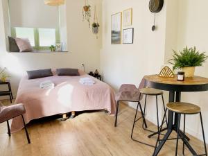 a bedroom with a bed and a table and stools at Modern Studio 1 in Historic Abbey in Cadier en Keer