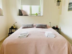a bedroom with a bed with two towels on it at Modern Studio 1 in Historic Abbey in Cadier en Keer +2 photos