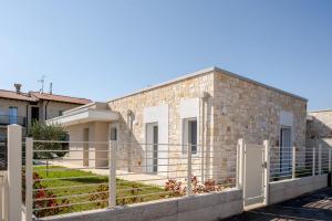 a brick house with a white fence at Villa Milvia in Colà di Lazise