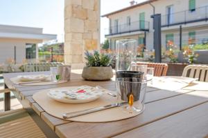 a wooden table with plates and utensils on it at Villa Milvia in Colà di Lazise