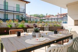 a wooden table on a patio with chairs at Villa Milvia in Colà di Lazise +25 photos