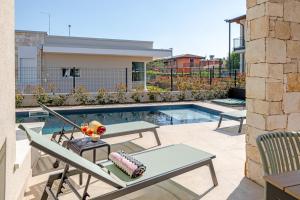 a patio with a pool and a table and chairs at Villa Milvia in Colà di Lazise