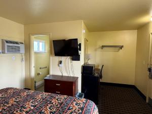 a hotel room with a bed and a flat screen tv at Crow's Nest in Tawas City