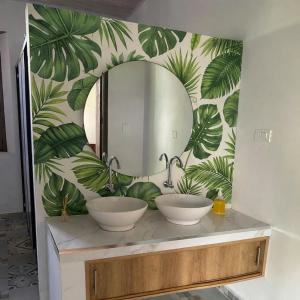 a bathroom with two sinks in front of a mirror at Casona El Remanso in Mariquita