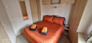 an orange bed in a small room with two towels at No 21 The Tummel in Forfar