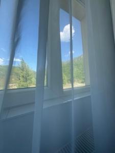 a window in a bathroom with a view of a mountain at Motel Vatra Bunătăților in Brezoi