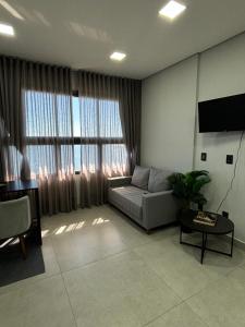 a living room with a couch and a large window at Flat Praia da Graciosa in Palmas