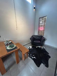a living room with a table and a chair at Chalé Reserva El Paso in Mairiporã +15 photos