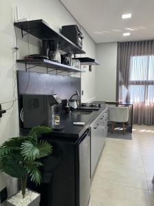 a kitchen with a sink and a stove top oven at Flat Praia da Graciosa in Palmas
