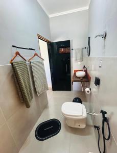 a bathroom with a toilet and a black door at Pouso Canastra - Chalés in São João Batista do Glória +32 photos