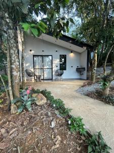 a white house with a table and chairs in front of it at Chalé Reserva El Paso in Mairiporã