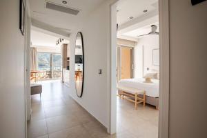 a white bedroom with a bed and a mirror at RIRIKA Beach Living, New Seaside Apartments in Plakias in Plakias