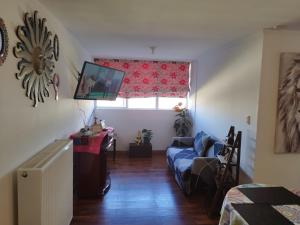 a living room with a blue couch and a window at Apartamento punta Arenas in Punta Arenas