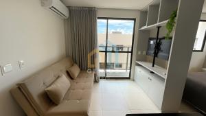 a living room with a couch and a large window at Compact Tambaú Genius Flats in João Pessoa