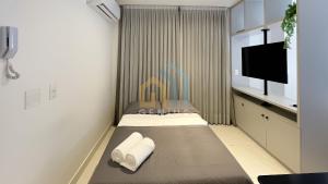 a small room with a bed and a flat screen tv at Compact Tambaú Genius Flats in João Pessoa