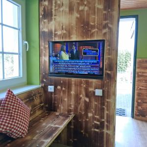 a living room with a tv on a wooden wall at Gaststätte Zur Hahnenquelle in Kirchhundem