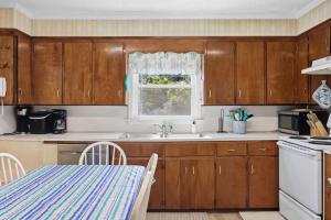 a kitchen with wooden cabinets and a sink and a window at 7604 - Uncle Pooh's Cottage in Avon