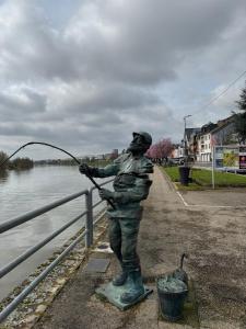 a statue of a man fishing in the water at Leo, apartment in Wasserbillig +3 photos
