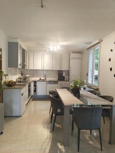 a kitchen with white cabinets and a table and chairs at Chez Carolayn in Geneva